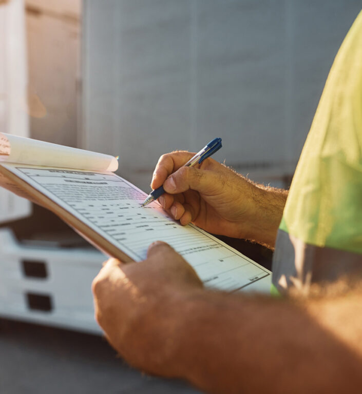 A supply chain worker checking shipment requirements off his checklist.