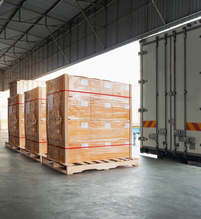 Three pallets of siran wrapped packages waiting to be loading onto a semi truck.