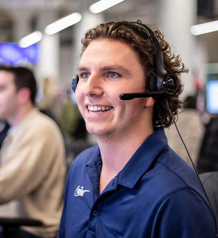 A Roadtex sales rep with a headset on helping a client book their next shipment.