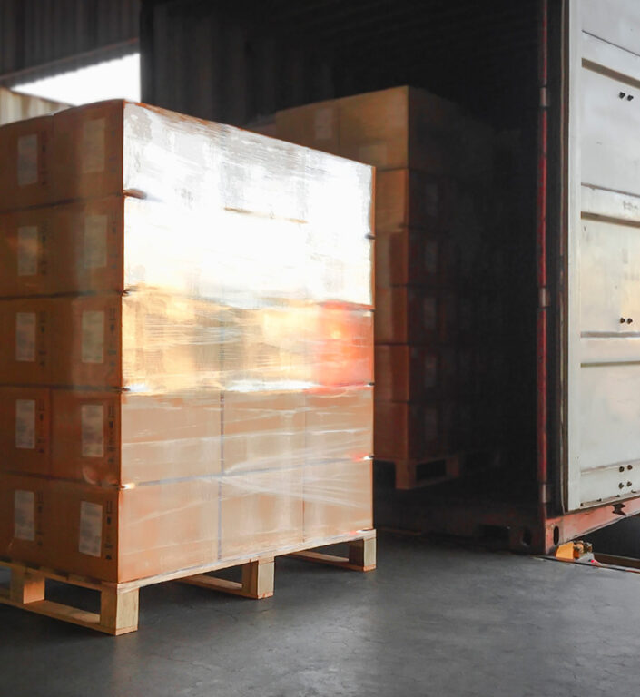 A wrapped shipment pallet waiting on a loading dock to be loaded onto a semi truck.