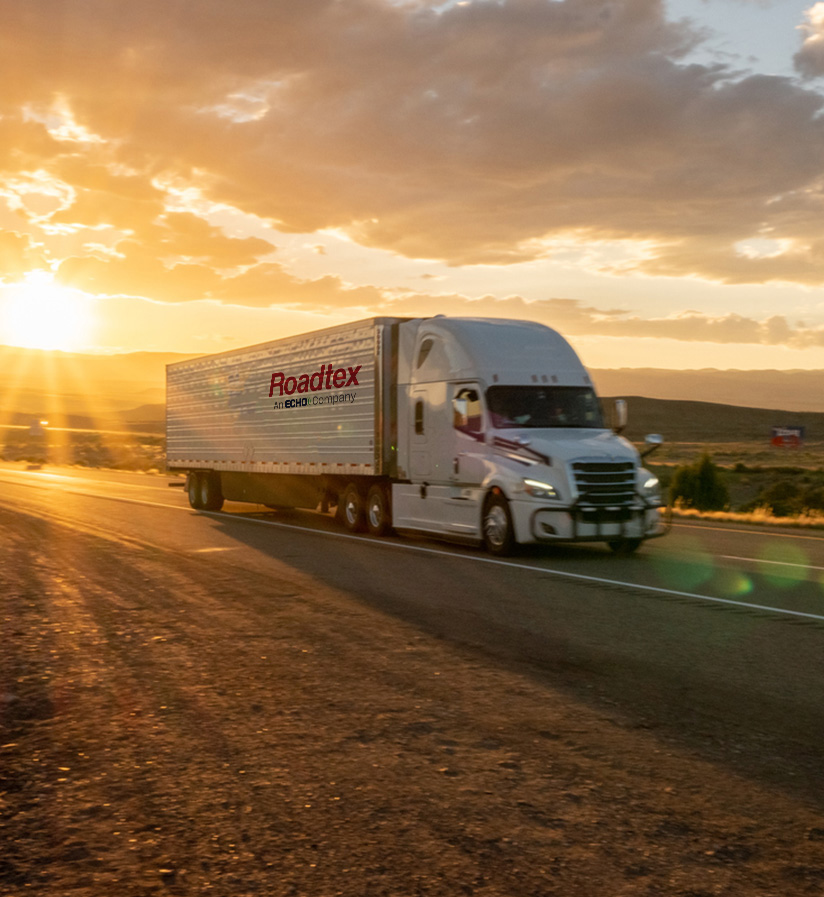 A white semi truck driving down the highway.