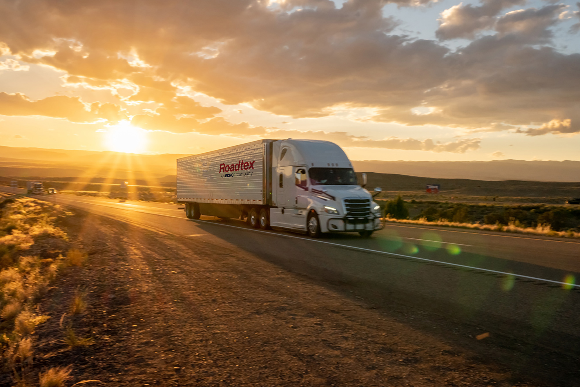 A white semi truck driving down the highway.