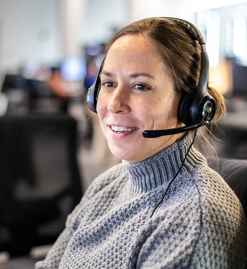 A Roadtex employee with a headset on working at their work station.