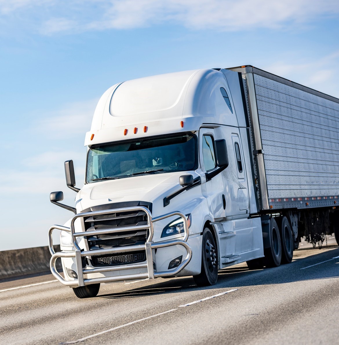 A white semi truck driving down the highway.