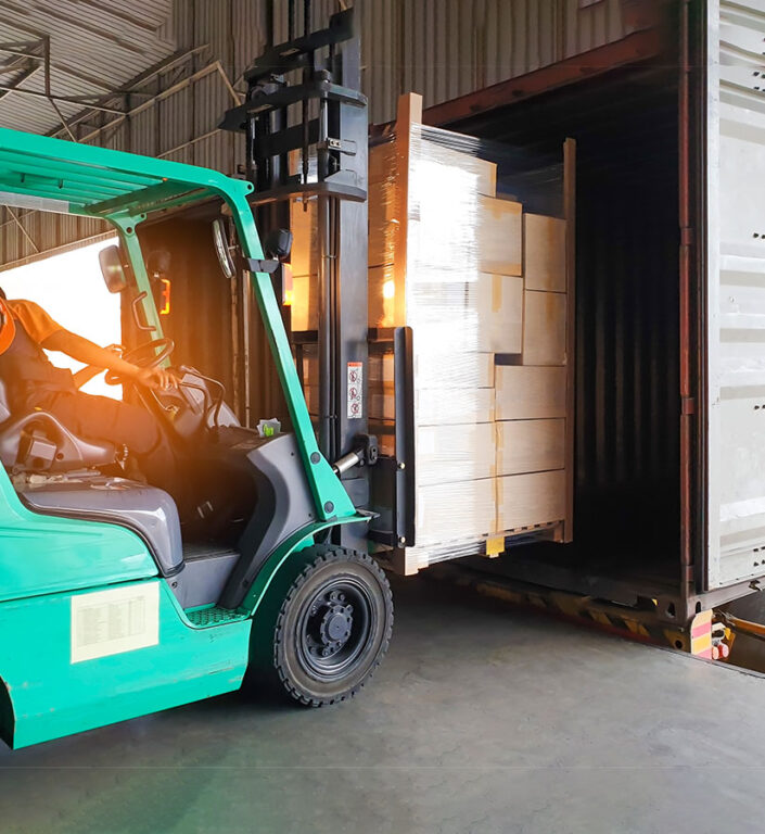 A siran wrapped shipment being unloaded at a loading dock.